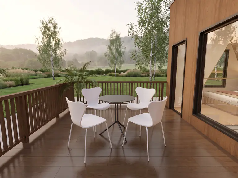 Prism balcony with a timber balustrade, bistro table and a view over the garden to the hills
