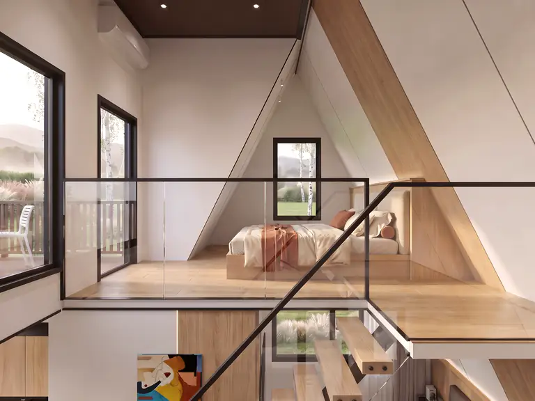 Prism mezzanine behind a glass balustrade: bed under the A-frame roof and a window to the balcony